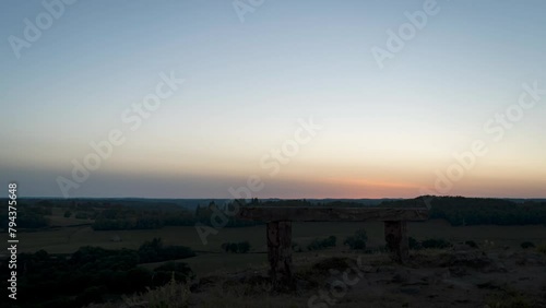 Sunset Timelapse vidéo with no clouds, orange sun, and Un bench, in Corrèze, france. 