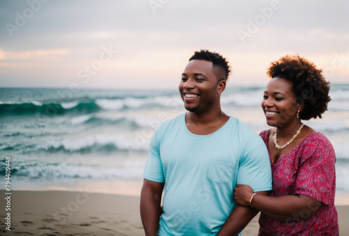 Joyful African American couple on a beach holiday, softly blurred sea and sand in the background
