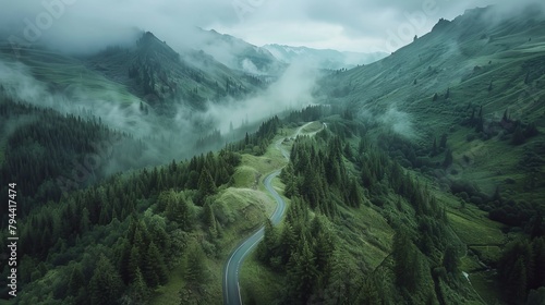 Aerial view of a winding road through a green forest and mountains, aerial photography drone shot with a high resolution top down view, landscape photo panoramic photograph