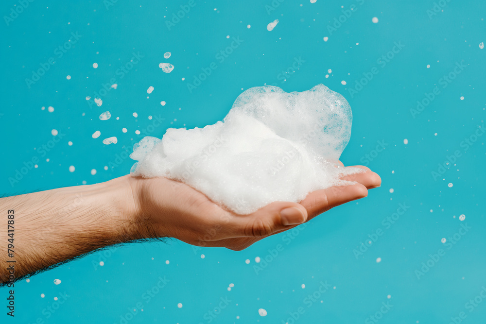 Male hands holding white lush foam on blue background