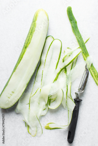 Overhead view of thinly sliced cucumbers, thin slices of cucumbers being prepared for salad