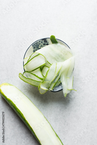 Overhead view of thinly sliced cucumbers, thin slices of cucumbers being prepared for salad