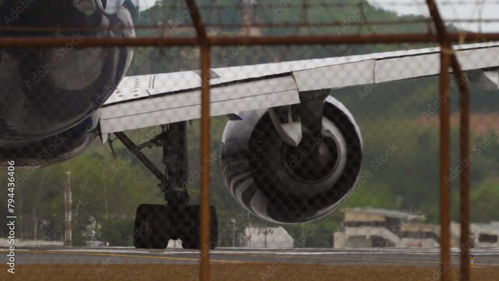 Passenger plane on the taxiway, turn to the runway. Airplane on the airfield, view through the fence Passenger plane on the taxiway, turn to the runway. Airplane on the airfield, view through the fence