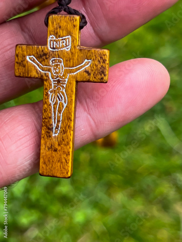 A rosary cross held in a hand, close-up photo