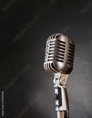 A vintage microphone with intricate design, against a dark background