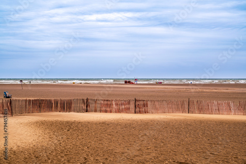 Photography red brown sand beach with snow fence distant breaking waves and blue sky room fo