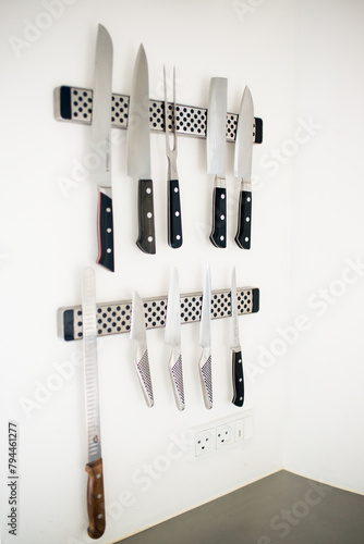 Set of professional knives on a white wall