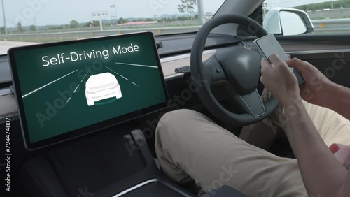 Self driving car or autonomous vehicle travel on speed highway with driverless system and autopilot mode allowing man driver relax and focus on smartphone without compromising safety. Fastidious photo