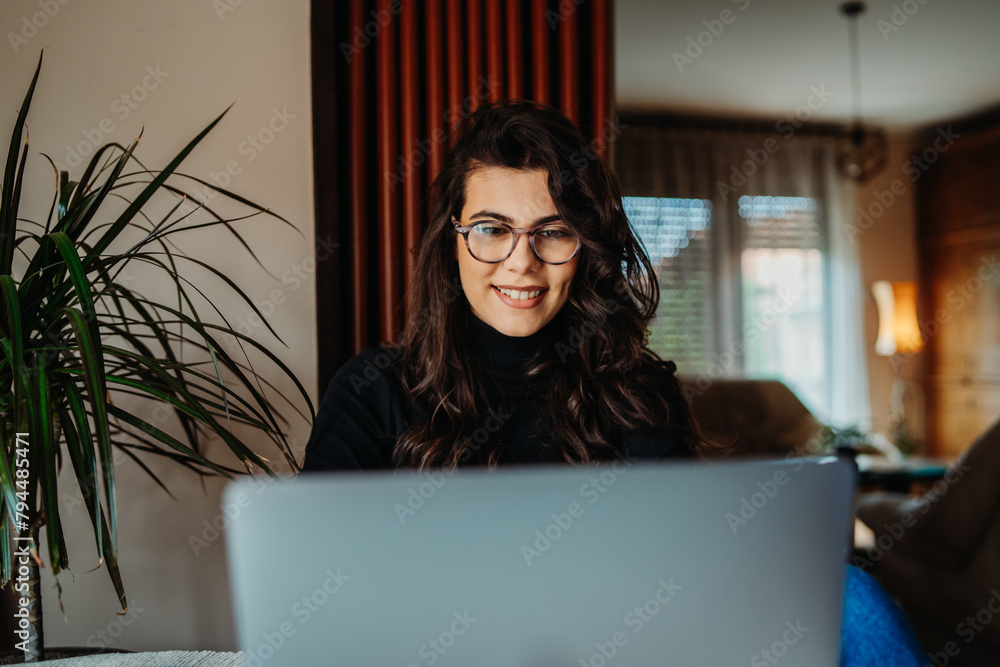 One young caucasian woman working on laptop from home One young caucasian woman working on laptop from home