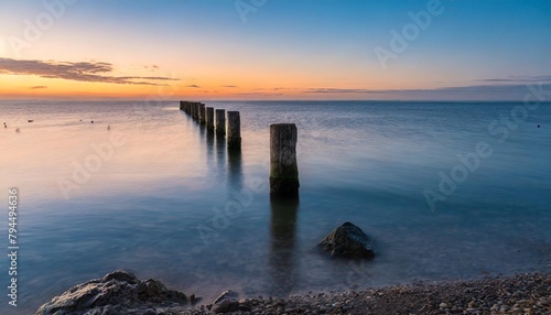 the sea and an old pier at the sunrise © Robert