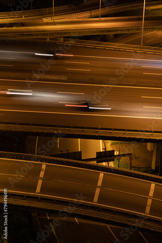 Estrada noturna com carros em alta velocidade photo