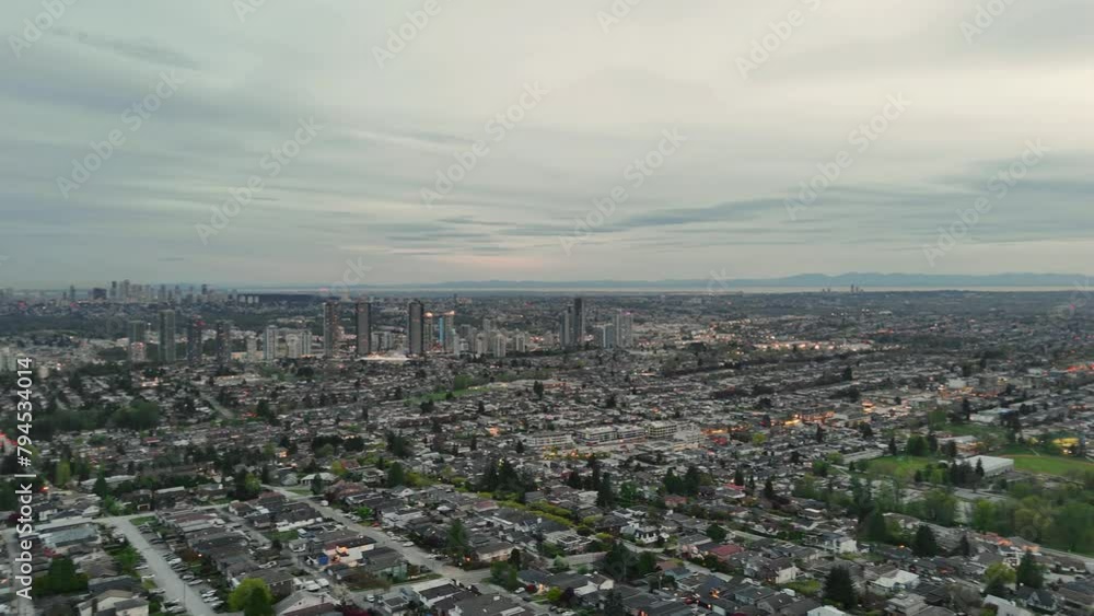 Panoramic aerial drone view (pan right) of the evening skyline of Vancouver and Burnaby next to the Burrard Inlet during a spring season in British Columbia, Canada Panoramic aerial drone view (pan right) of the evening skyline of Vancouver and Burnaby next to the Burrard Inlet during a spring season in British Columbia, Canada