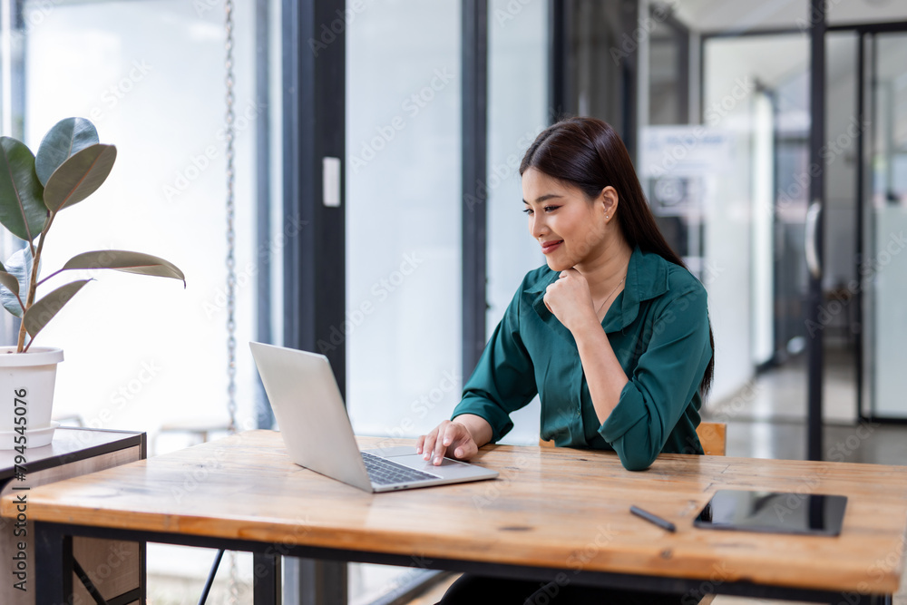 Portrait of happy an Asian businesswoman sitting at her desk office business plan investment, finance analysis concept.Looking at the camera. Portrait of happy an Asian businesswoman sitting at her desk office business plan investment, finance analysis concept.Looking at the camera.