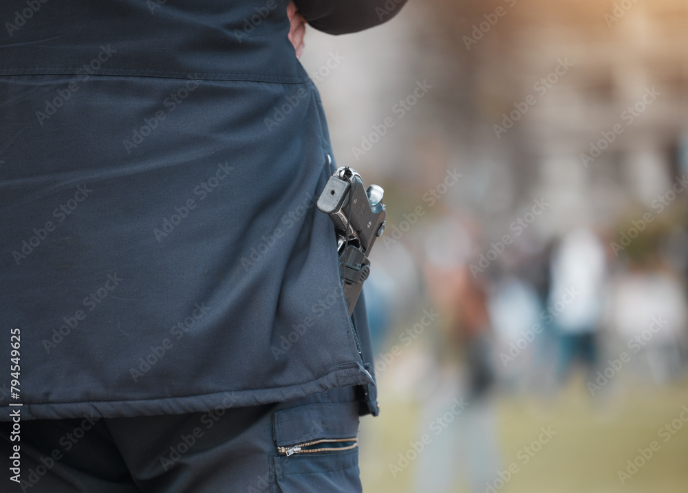 Police, person and gun with back at protest with safety, monitor and outdoor for crowd control in city. Security guard, weapon and government agent in road, street and protection for danger at rally