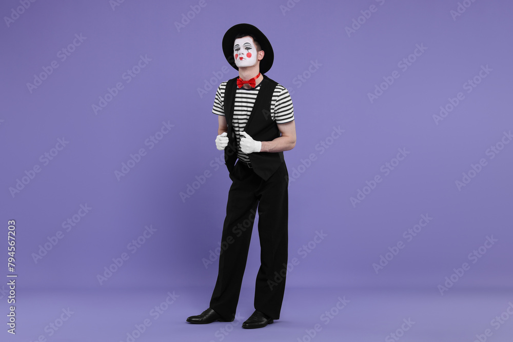 Funny mime artist in hat posing on purple background Funny mime artist in hat posing on purple background