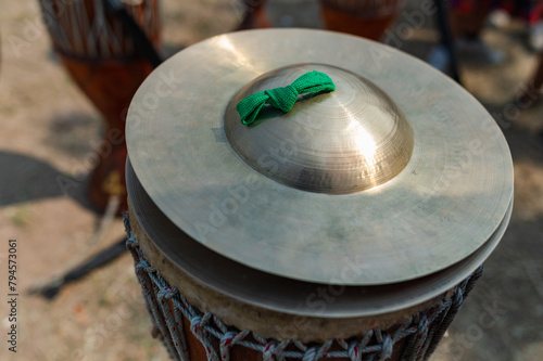 A fanfare cymbal rests on a long drum. Folk music bands play in Thailand