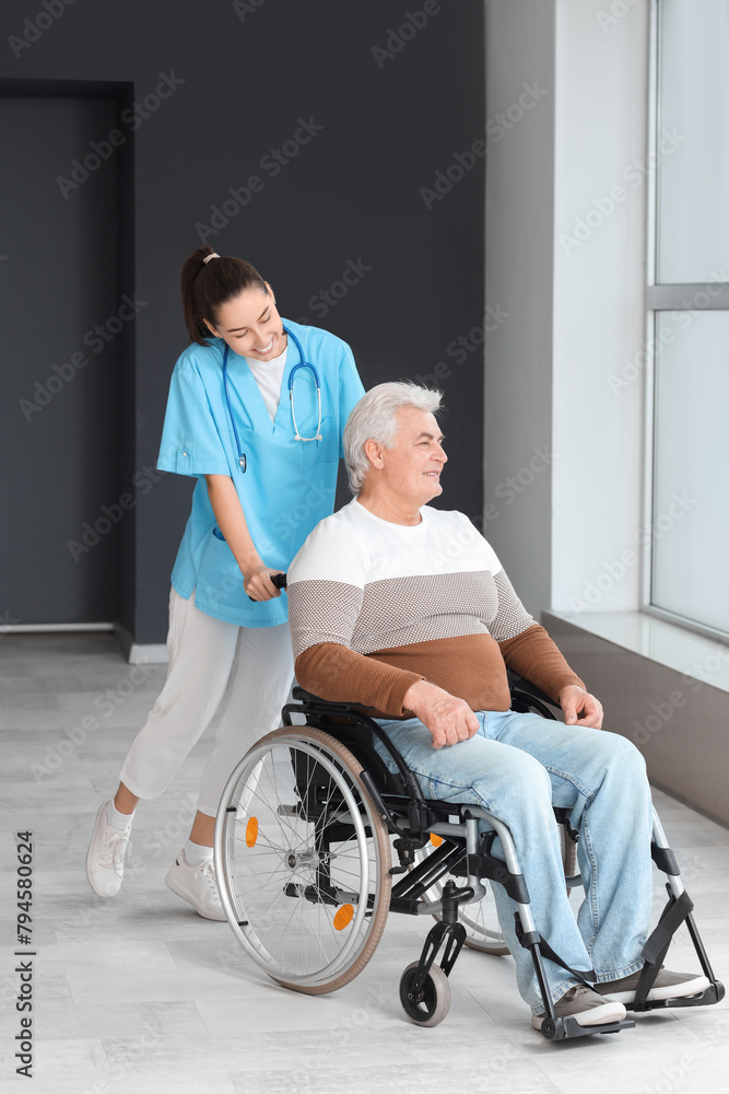 Senior man in wheelchair and nurse at hospital Senior man in wheelchair and nurse at hospital