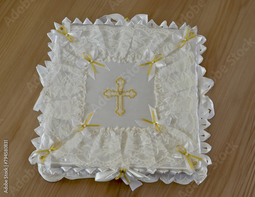 The baptismal accessories box is covered with a cover engraved with the cross in yellow with yellow ribbons