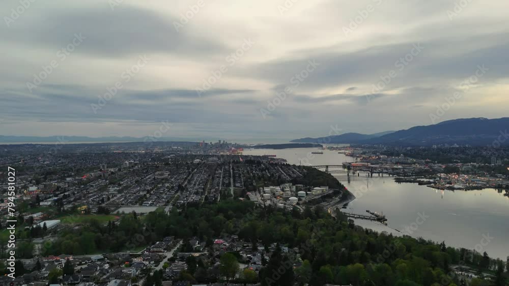 Panoramic aerial drone view (pan right) of the evening skyline of Vancouver and Burnaby next to the Burrard Inlet during a spring season in British Columbia, Canada Panoramic aerial drone view (pan right) of the evening skyline of Vancouver and Burnaby next to the Burrard Inlet during a spring season in British Columbia, Canada