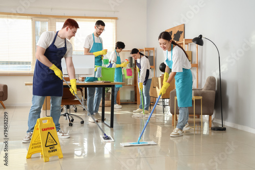 Young janitors cleaning in office