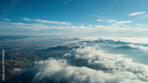 This illustration depicts a birds eye view of clouds floating above majestic mountains in the sky. The mountains are rugged and towering  while the clouds are fluffy and expansive.