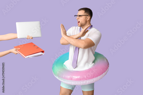 Billede på lærred Angry office worker with inflatable ring showing refusal sign against female han