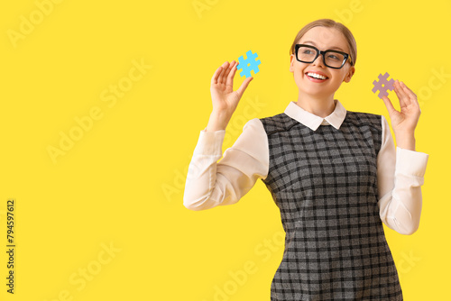 Young teacher with hashtag signs on yellow background
