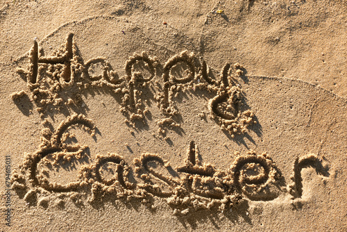 Text HAPPY EASTER written on sand on sea beach