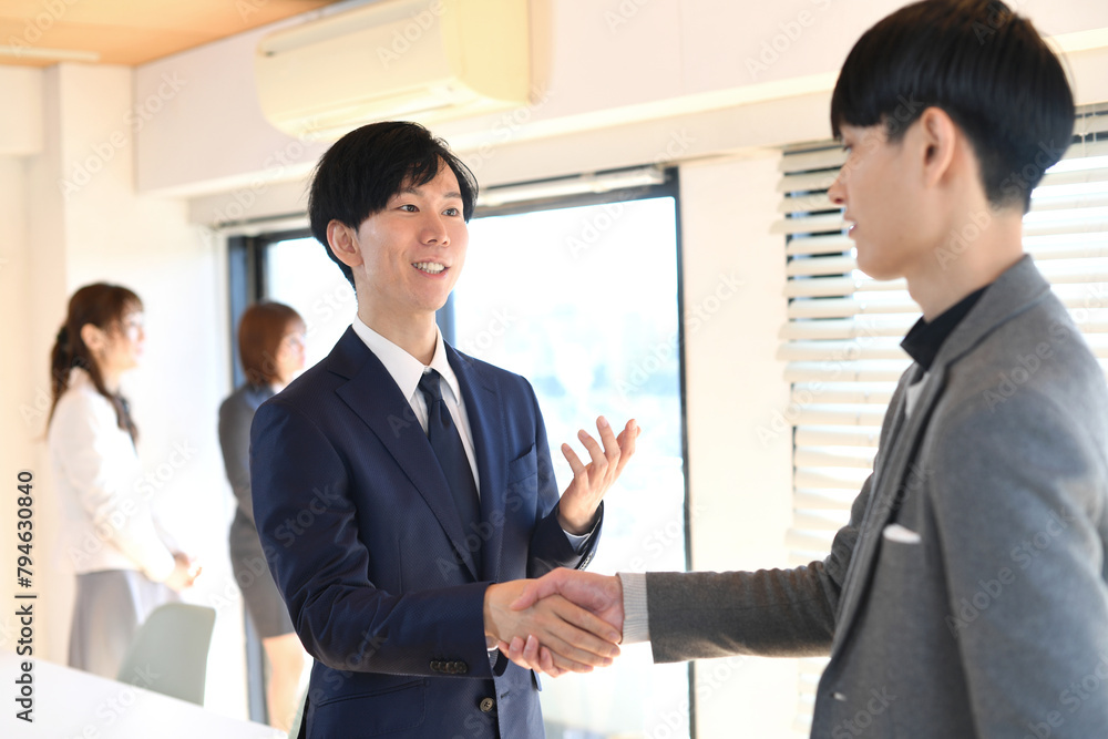 屋内で握手をするアジア人のビジネスマン達 屋内で握手をするアジア人のビジネスマン達