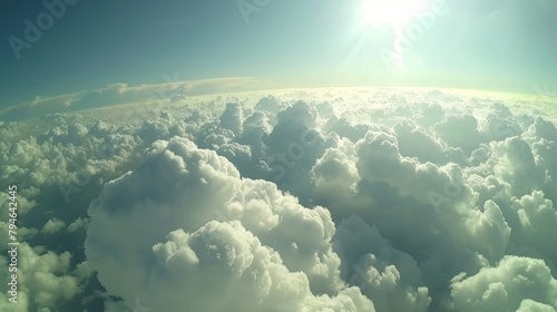 The sun is visible high above a layer of clouds in the sky, casting light and warmth onto the scene below. © Justlight