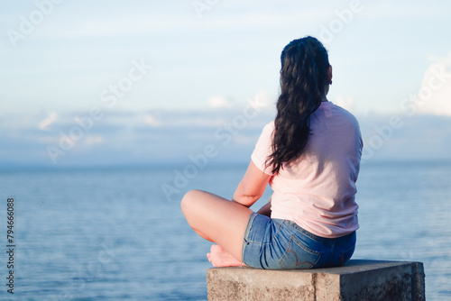 Mujer sentada mirando hacia el horizonte