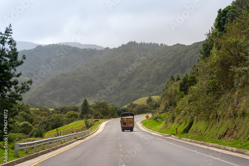 Truck on a Colombian countryside road with hills in the background.