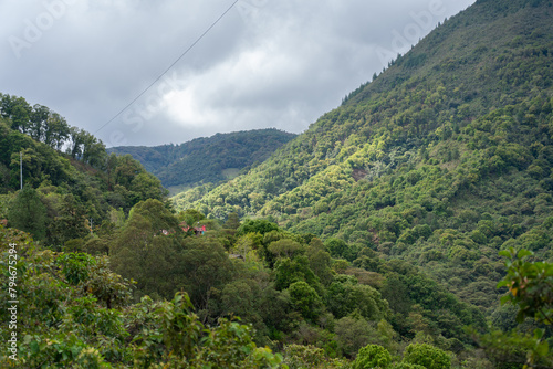 Small house between mountains full of trees in a Colombian landscape.