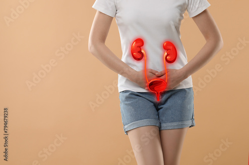 Woman suffering from cystitis on beige background, closeup. Illustration of urinary system photo