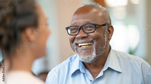 Senior leader smiling and talking to younger colleagues during a mentorship meeting in a corporate office