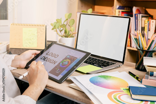 Designers are creating graphic works on tablet and computer. Choosing color shades for work