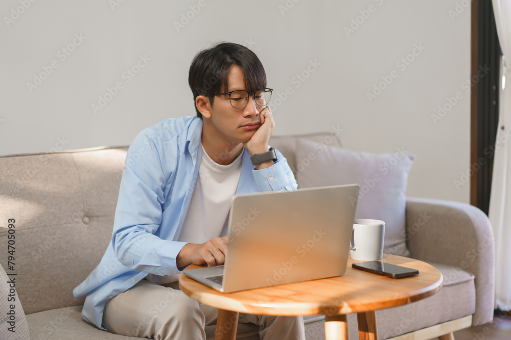 Business lifestyle, Businessman resting chin on hand with bored and tired while working on laptop Business lifestyle, Businessman resting chin on hand with bored and tired while working on laptop