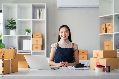 Woman asian in an online store check the customer address and package information on the laptop. Online shopping concept © Natee Meepian