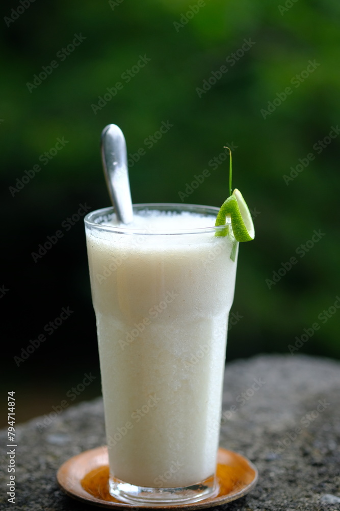 soursop juice in a clear glass. fresh drink from tropical fruit. stone table. soursop juice in a clear glass. fresh drink from tropical fruit. stone table.