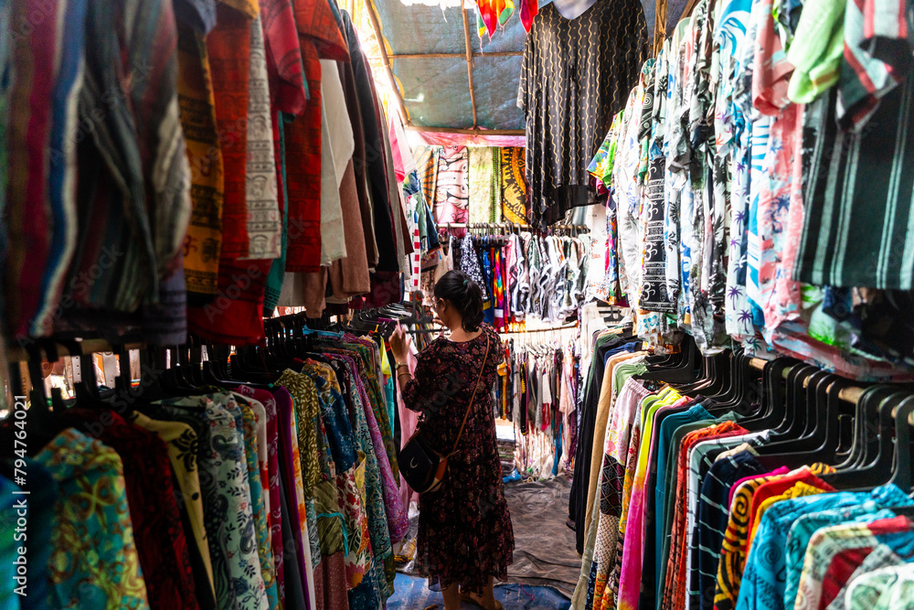 Obraz premium Happy young Indian woman shopping from Anjuna flee market in Goa, India 