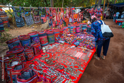Fotografia Happy young Indian woman shopping from Anjuna flee market in Goa, India