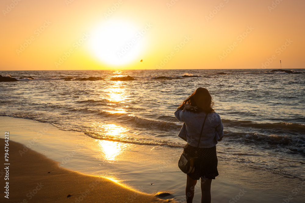 Happy Carefree Indian Woman Enjoying Beautiful Sunset on the Beach in Goa
