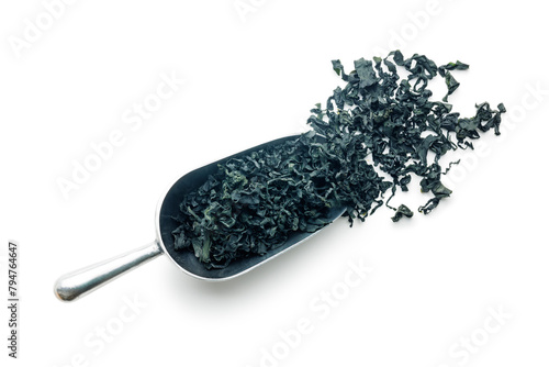 Dried wakame seaweed in scoop isolated on white background.