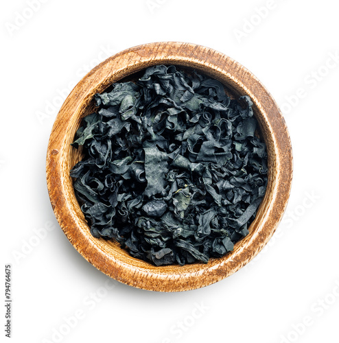 Dried wakame seaweed in bowl isolated on white background.