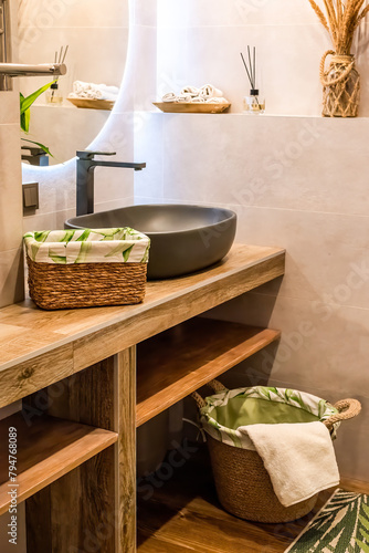 wooden wicker basket with towels on wooden shelf for bathroom