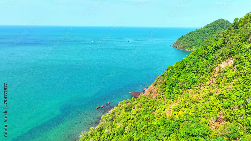 Surrounded by turquoise seas, a drone's view reveals a paradise island with lush green rainforests and majestic mountains. Journey and travel concept. Ko Chang island, Thailand. 
