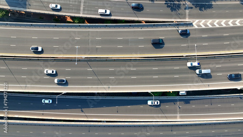 Sticker Aerial view, High above, a drone gracefully glides over a bustling highway, capturing the endless flow of vehicles below