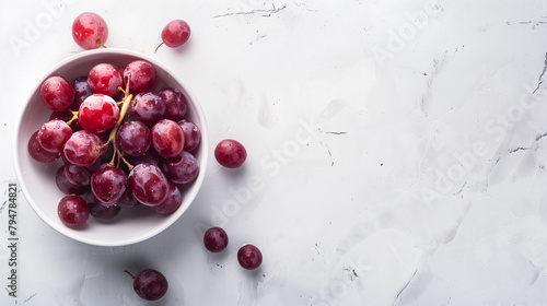 Red grapes in a bowl on a white table top view space on the right