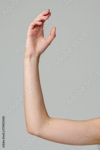 Female hand sign against gray background in studio