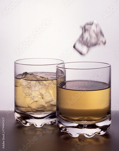 Two glasses of Whiskey on a black table top
